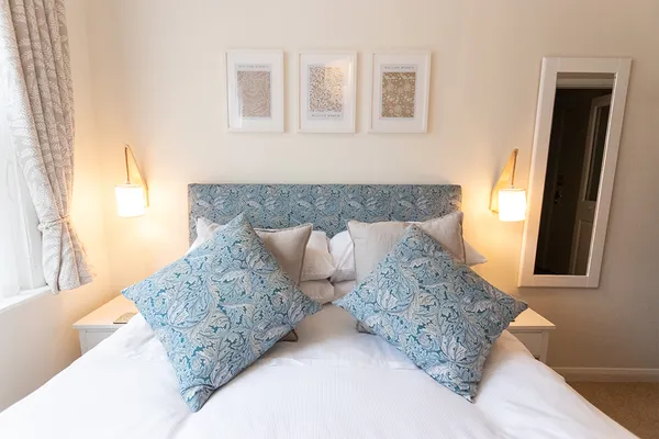 Bed with pillows on top and art on the wall